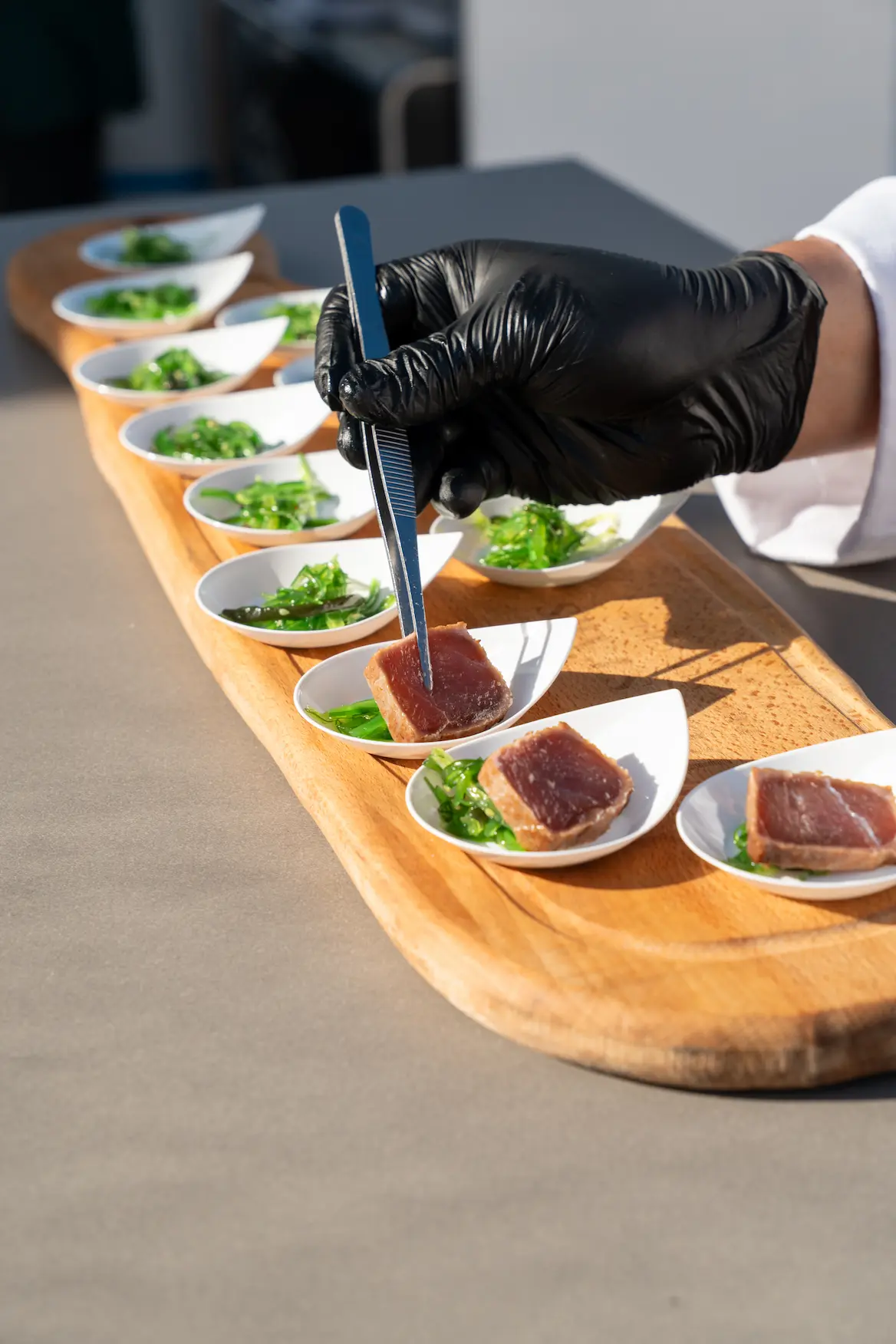 Chef serving tuna and wakame tasting spoons