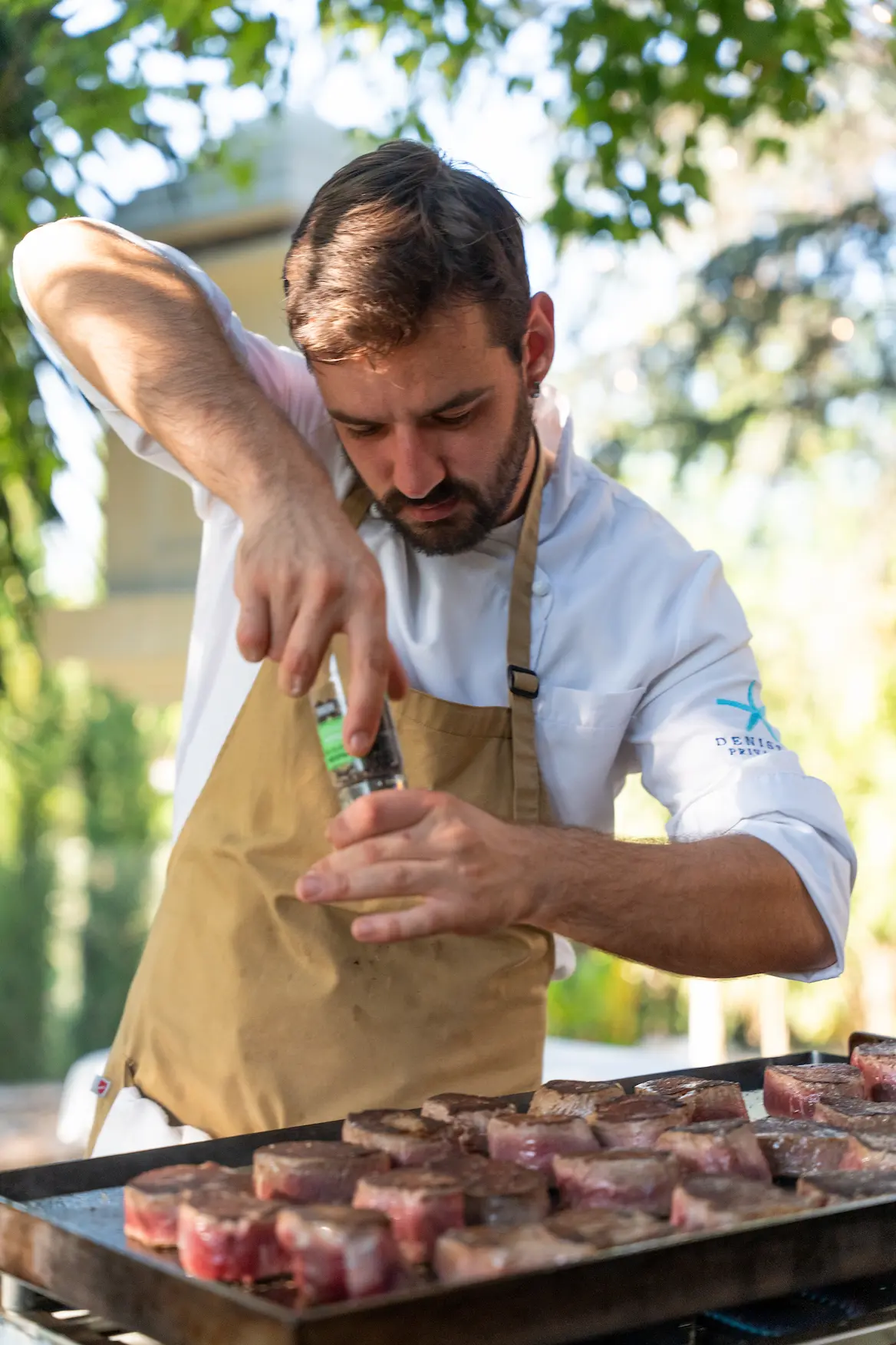 Chef seasoning premium meat before a private villa service